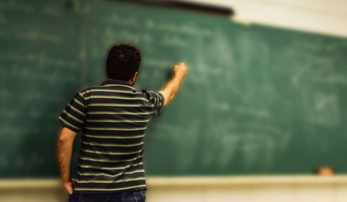 Teacher writing on blackboard